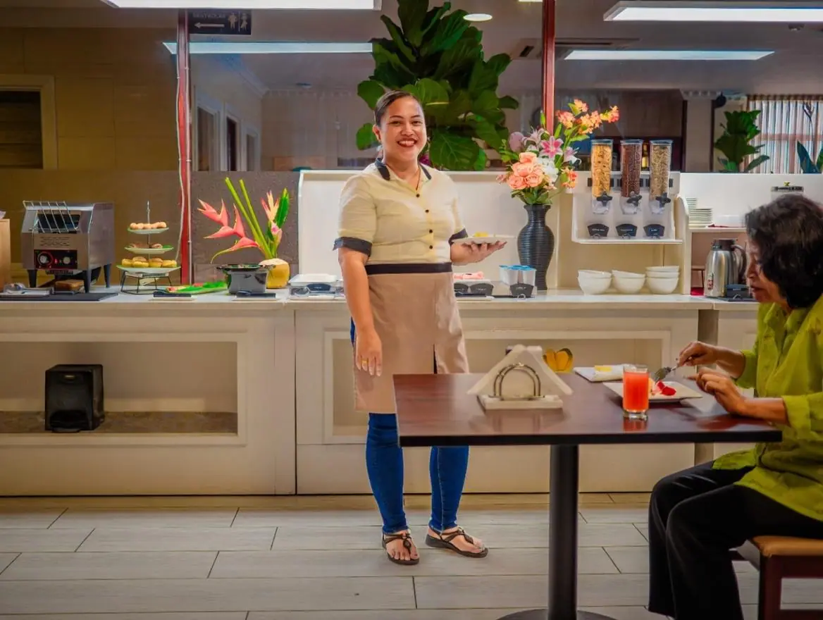A Hotel Palacio staff member serving breakfast to a guest